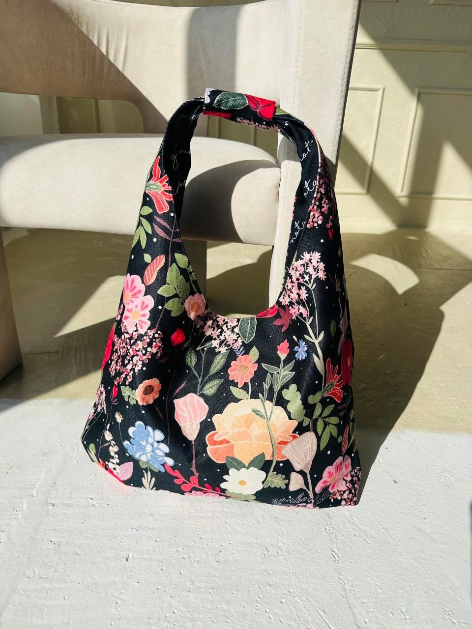 7. Garbanota Moon Bag - Curly Summer Night with floral pattern on beige chair, lifestyle setting