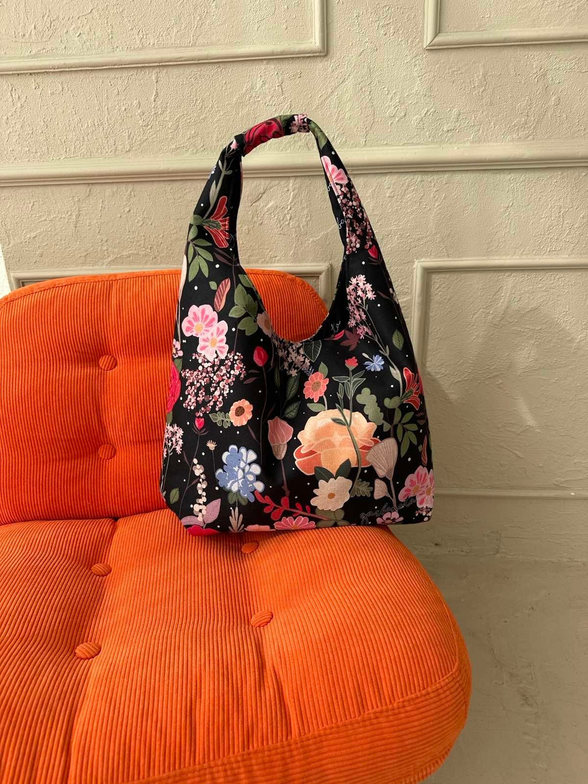 6. Garbanota Moon Bag - Curly Summer Night with floral design on orange chair, lifestyle setting