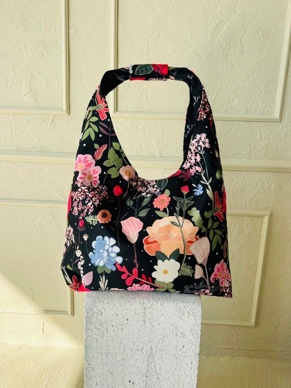 10. Garbanota Moon Bag - Curly Summer Night with floral design on white pedestal, studio setting