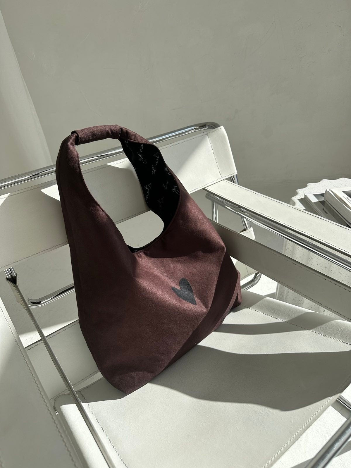 4. Garbanota Moon Bag Heart in brown on white chair, emphasizing heart design and lightweight material