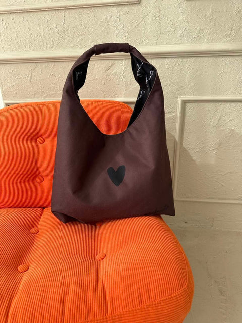2. Garbanota Moon Bag Heart in brown on orange chair, highlighting heart design and soft fabric