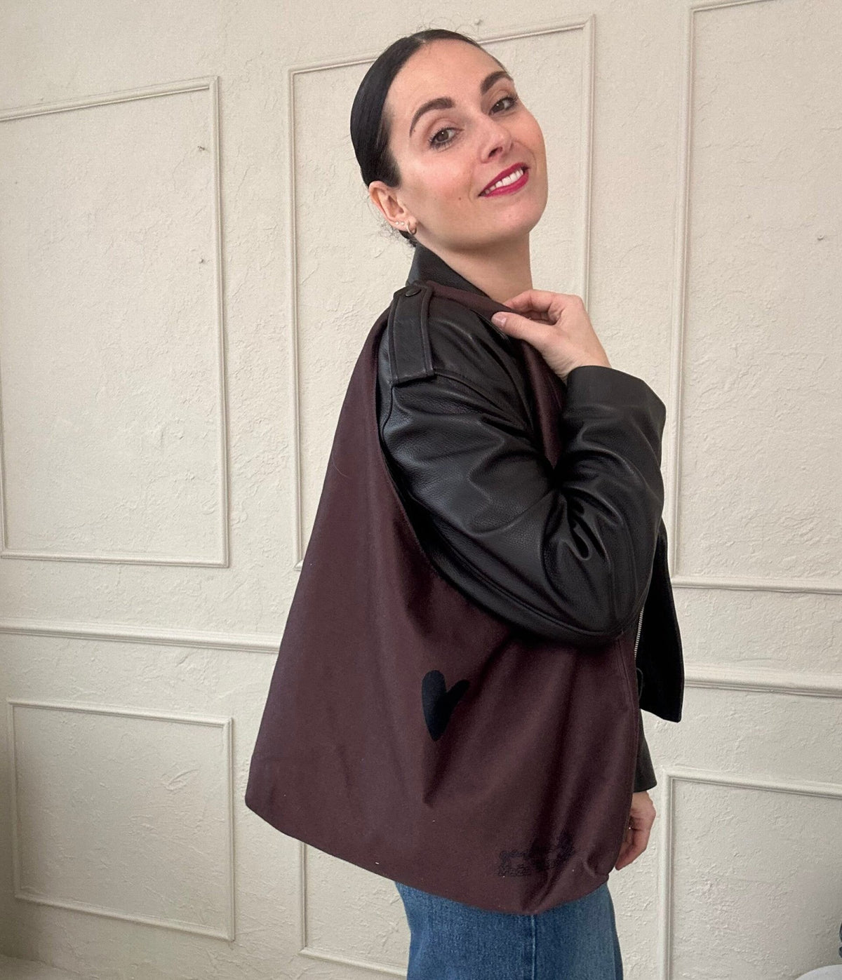 1. Woman wearing Garbanota Moon Bag Heart in brown, showcasing spacious design and heart detail