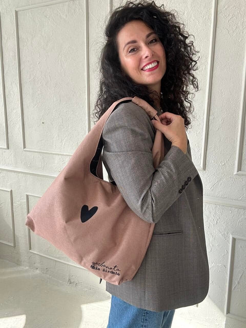 2. Woman showcasing Garbanota Moon Bag Heart in cream, worn over shoulder, lifestyle setting