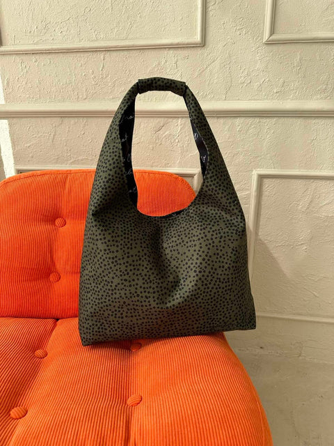 2. Garbanota Moon Bag Heart in khaki polka dots placed on an orange chair, highlighting its stylish and functional design