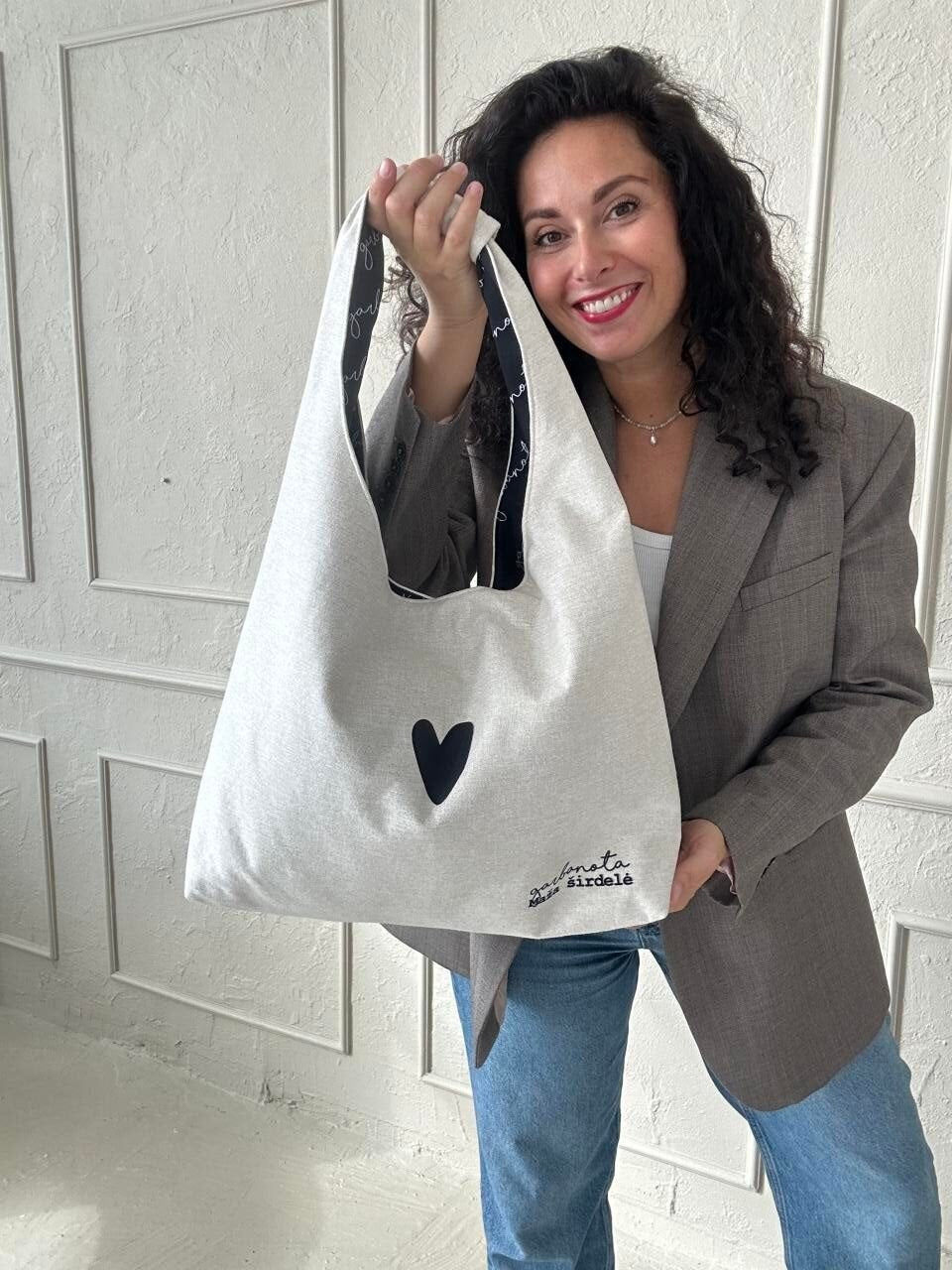 2. Woman showcasing Garbanota Moon Bag Heart in white, highlighting heart design