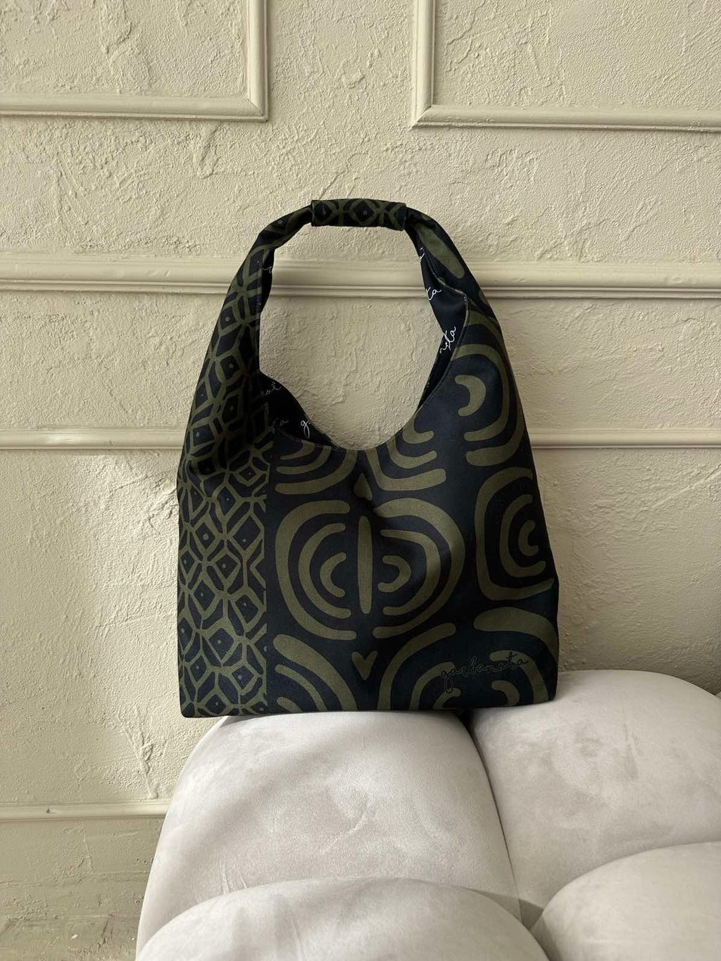 8. Garbanota Moon Bag in khaki pattern on a plush chair, highlighting comfort and style