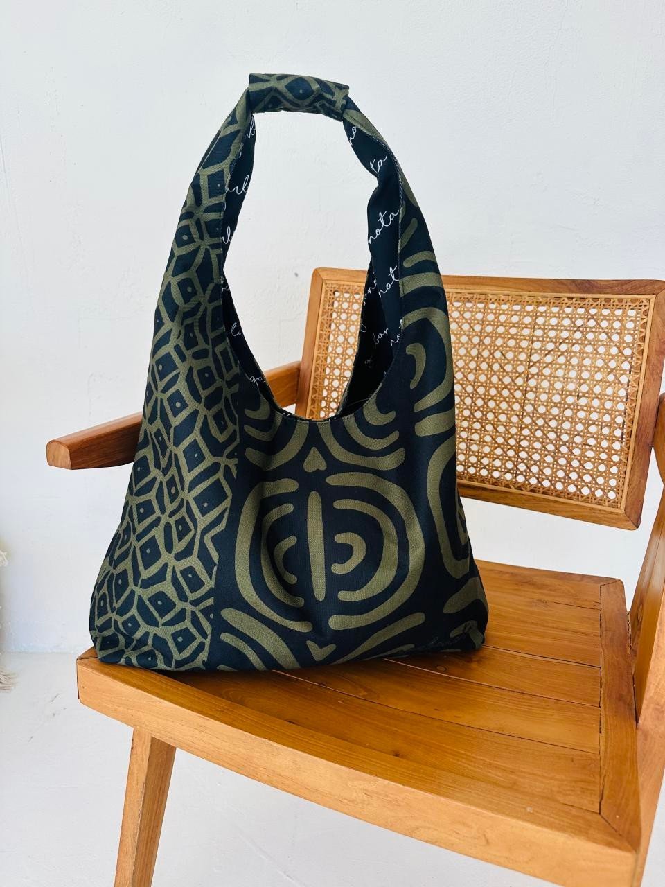 4. Garbanota Moon Bag in khaki pattern on a wooden chair, showcasing intricate pattern