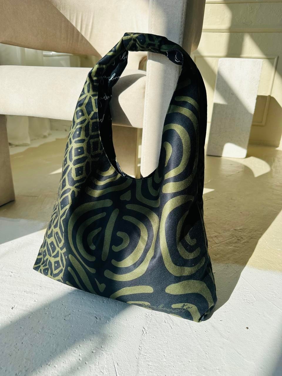 5. Garbanota Moon Bag in khaki pattern on a light floor, highlighting soft fabric