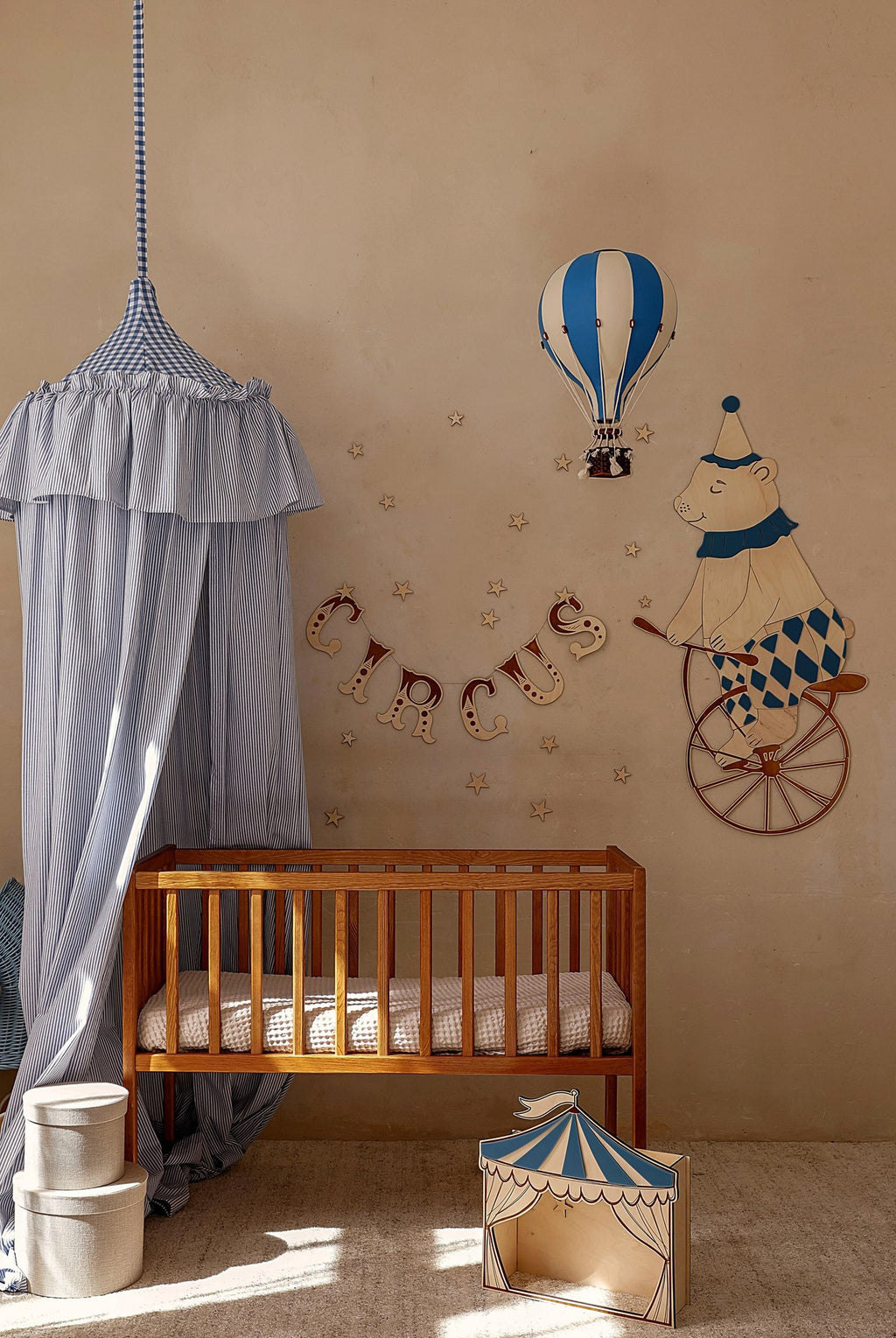 5. Wooden wall garland spelling 'CIRCUS' above a crib with a bear on a unicycle and hot air balloon decor