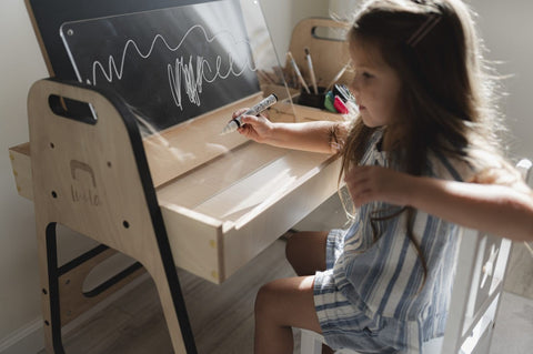 1. Girl using chalkboard on Luula Julle table in a bright room