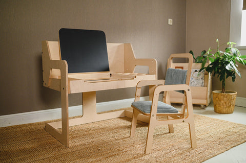 1. Luula multisensory art table with birch plywood and matte white finish in a room setting, featuring a chalkboard and compartments for art supplies