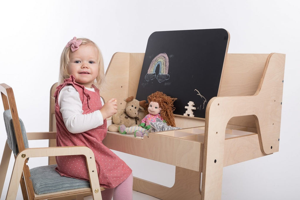 5. Young girl playing with toys at Luula table, featuring chalkboard and birch plywood construction