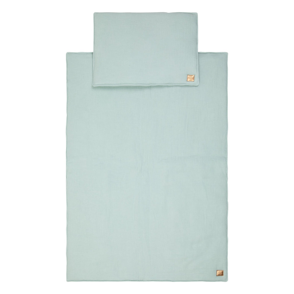 2. Studio shot of mint muslin baby blanket and pillow set with visible brand tag