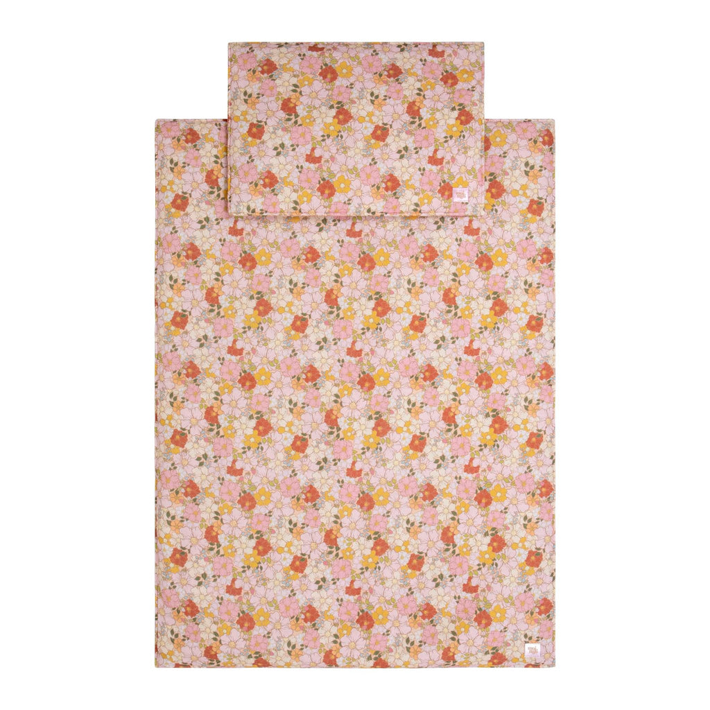3. Flat lay of muslin baby blanket and pillow set with pink, yellow, and white floral pattern