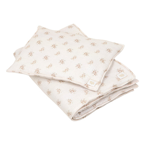 2. Studio shot of muslin baby blanket and pillow set with boho flower print, highlighting soft cotton material