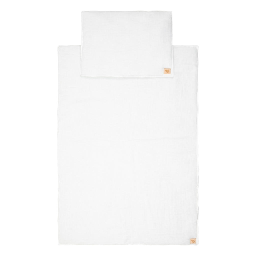 4. Flat lay of cream muslin baby blanket and pillow set with Moi Mili logo