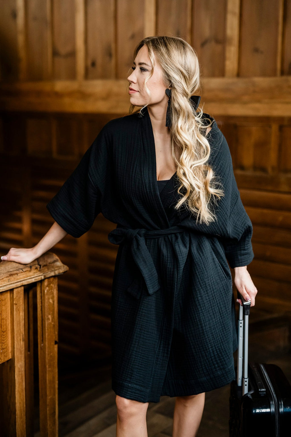 1. Women's black muslin kimono by RÄTT, styled with a waist belt, worn by a model in a wooden interior setting