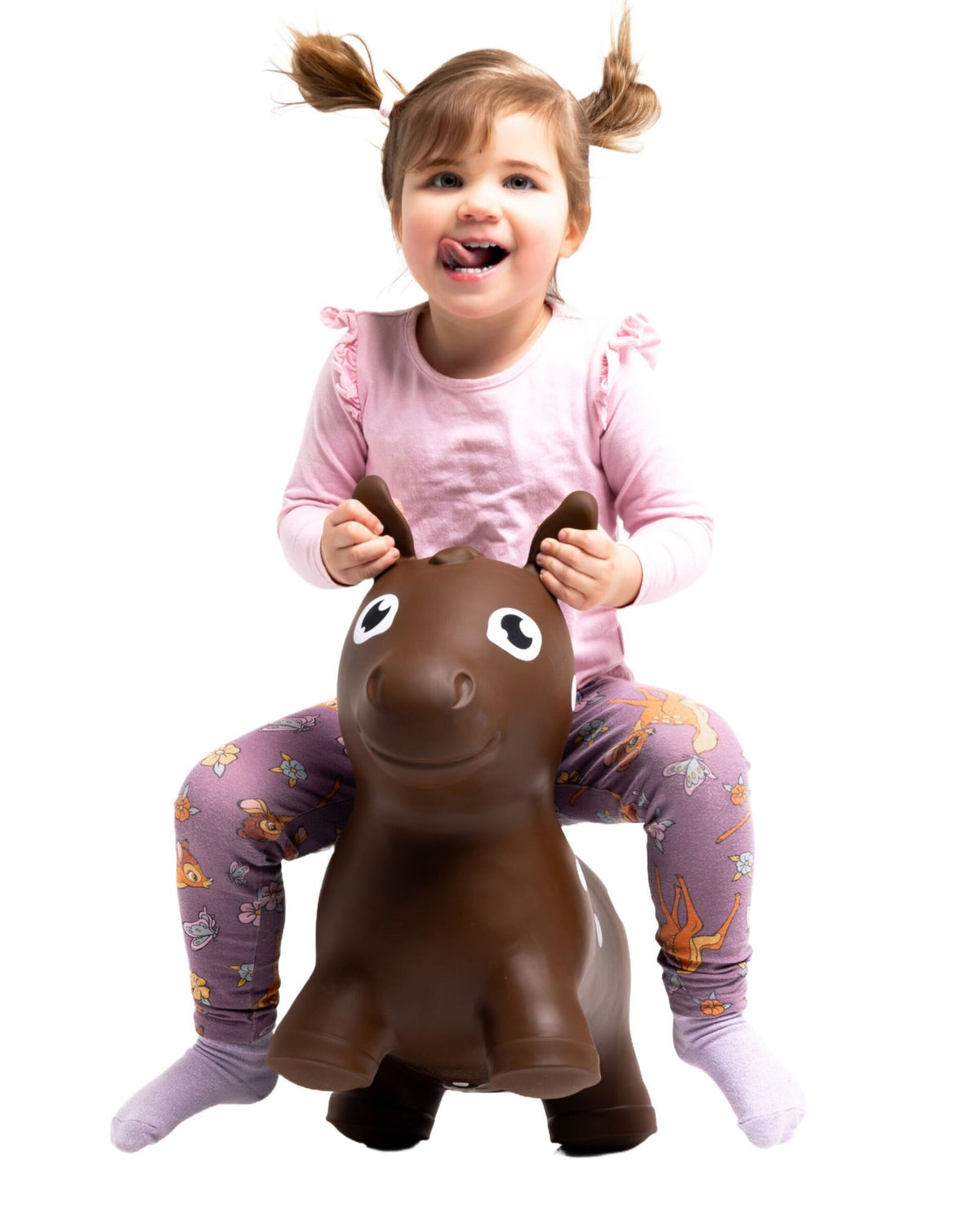 3. Girl in pink top and purple leggings riding brown horse hopper toy indoors