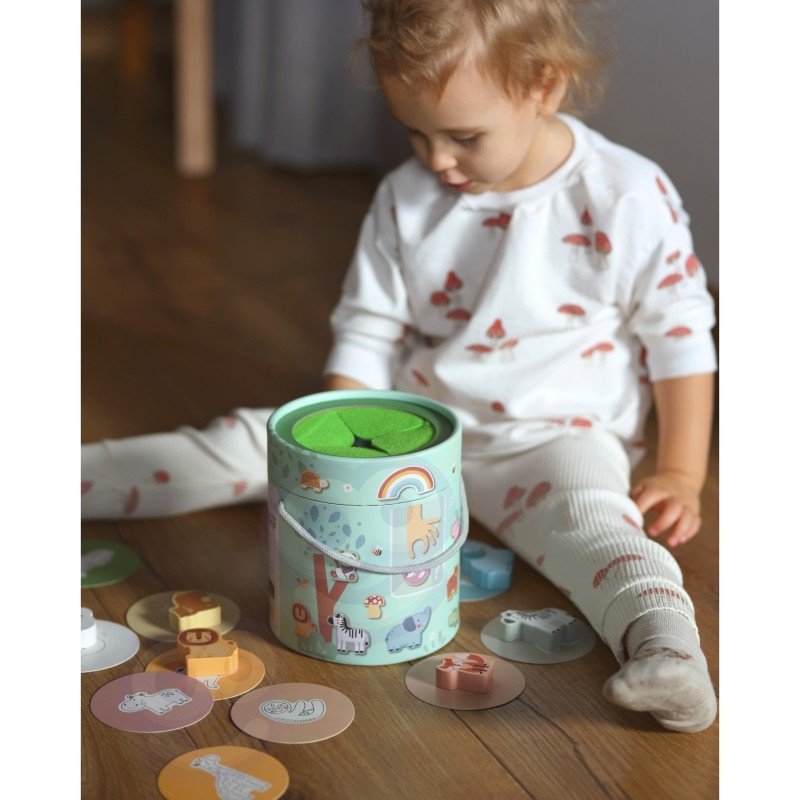 8. Child sitting on floor playing with Woopie Mystery Box and matching cards