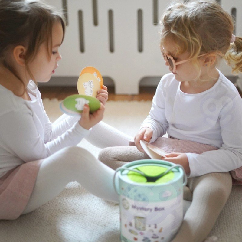 10. Two children playing with Woopie Mystery Box, holding matching cards