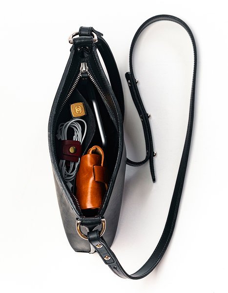 3. Top view of open black leather Stella Soomlais handbag showing interior with phone, wallet, and accessories