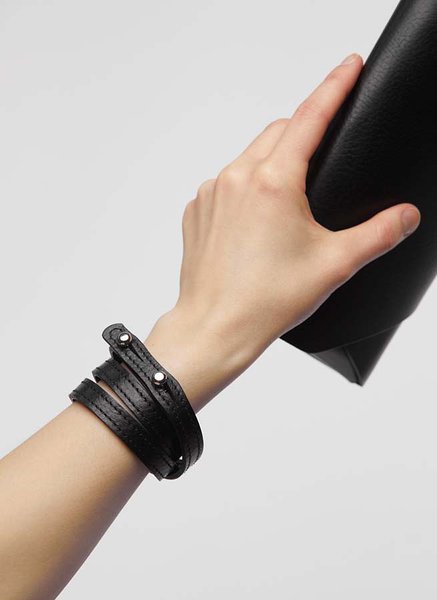 15. Hand holding black leather Stella Soomlais Capital of Plenty clutch-wallet with wrist strap