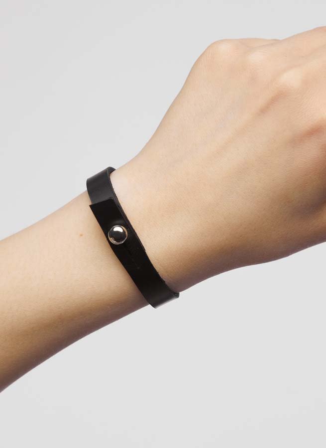 1. Person wearing black leather wristband with silver screw button by Stella Soomlais