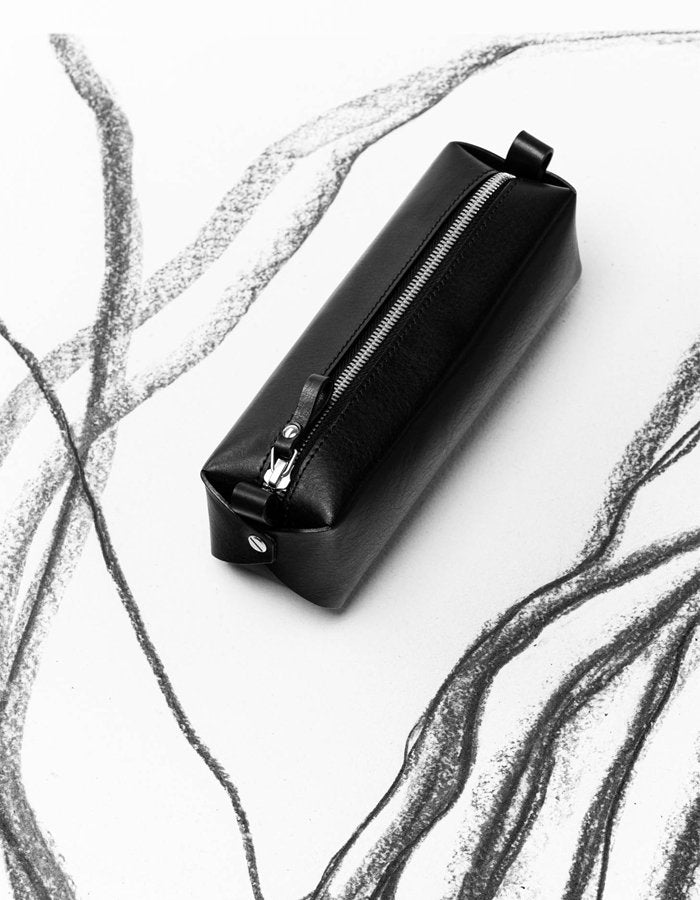 1. Black leather pencil case by Stella Soomlais on artistic sketch background, showcasing minimalist design and zipper detail