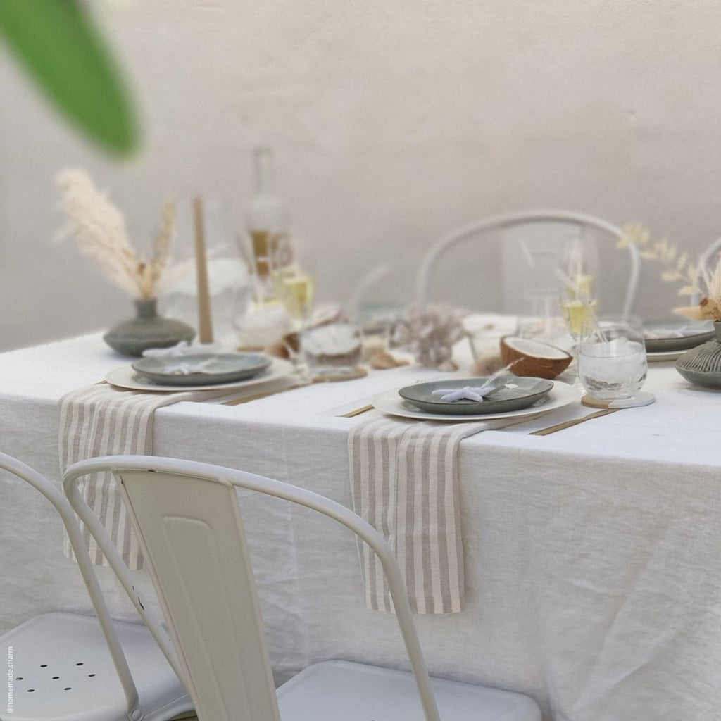 3. Elegant dining table with striped linen napkins and minimalist decor in a natural setting