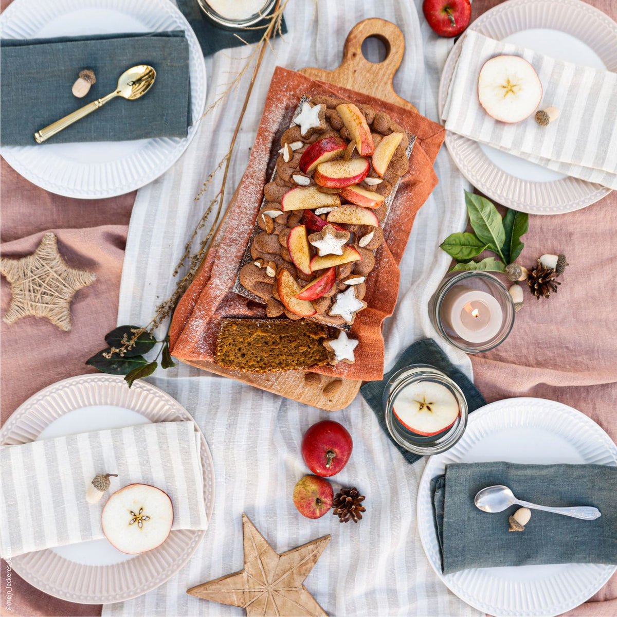 10. Festive table setting with striped and solid linen napkins, bread, and fruit on a wooden board