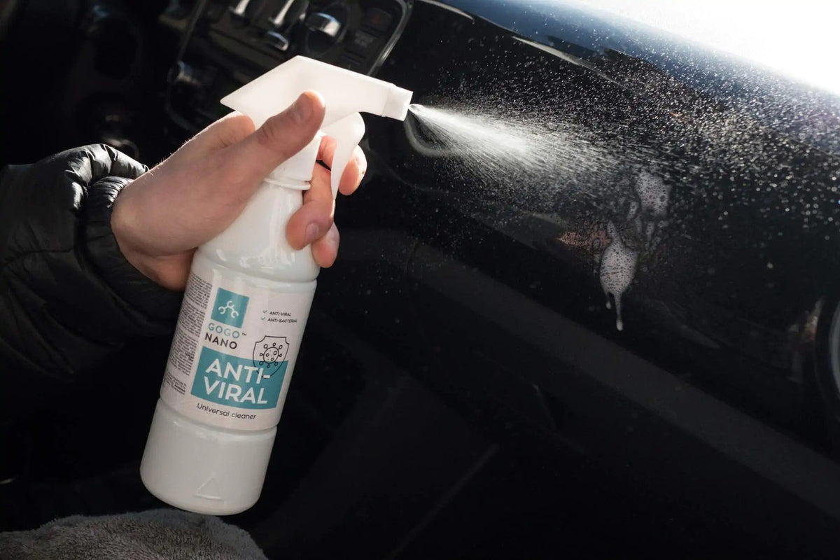 1. Person using GoGoNano Anti-Viral cleaner on car dashboard, spraying disinfectant