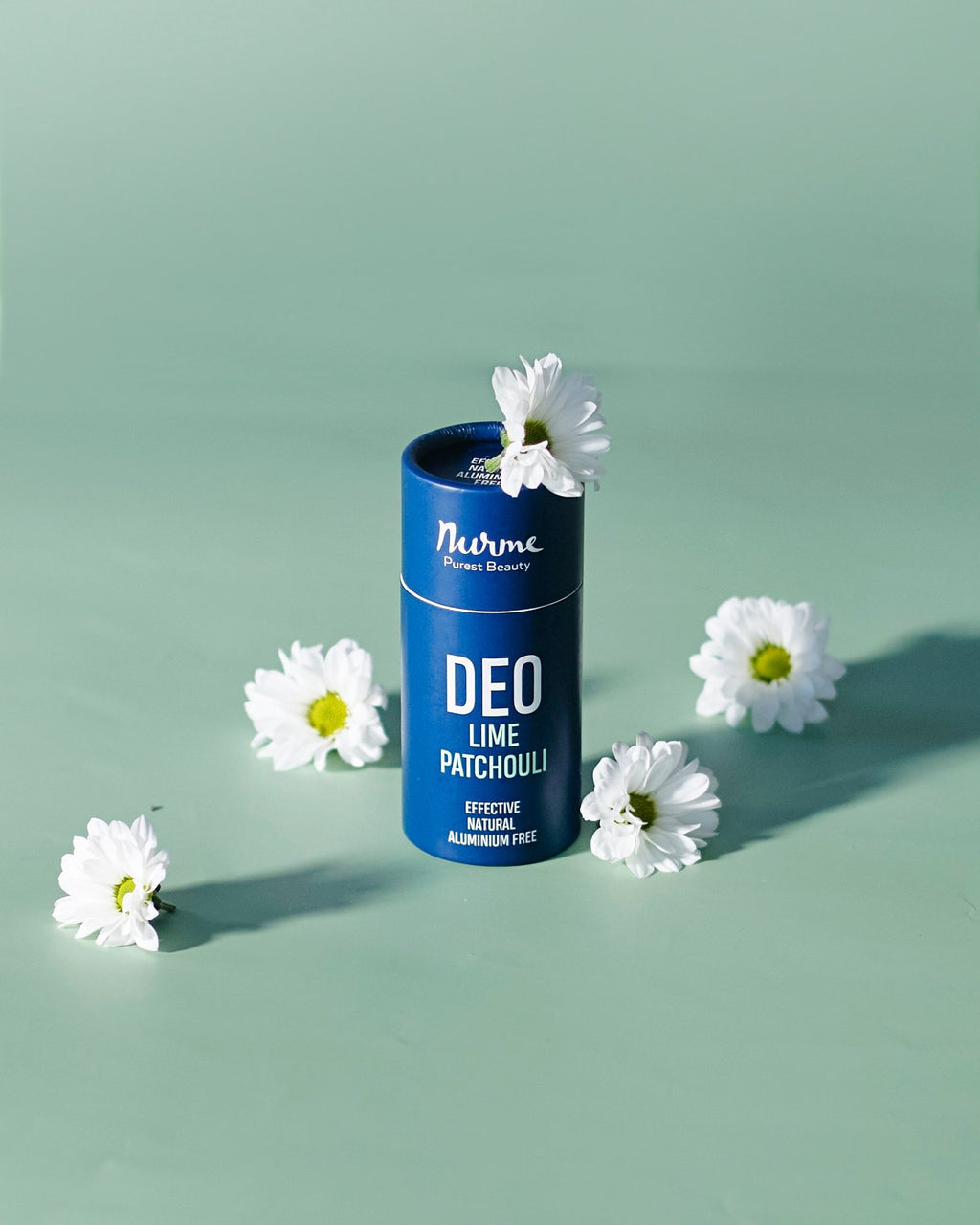 6. Nurme Lime & Patchouli deodorant in blue packaging with white flowers on a green background