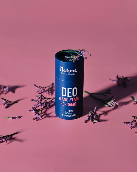 1. Nurme Ylang-Ylang Bergamot deodorant in eco-friendly packaging on pink background with purple flowers