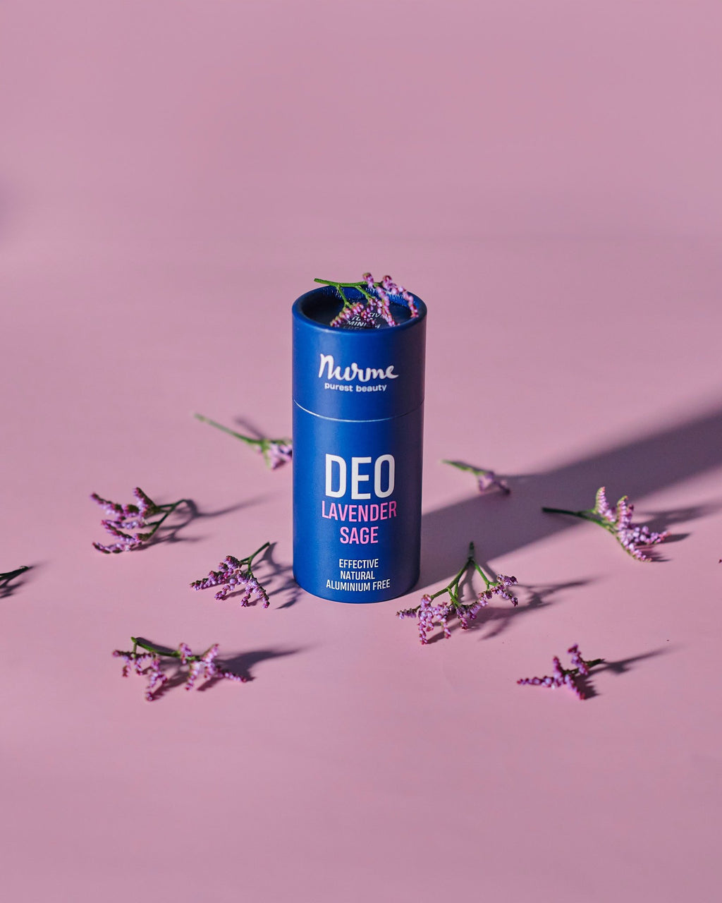4. Nurme Lavender Sage deodorant in blue packaging with lavender flowers on a pink background