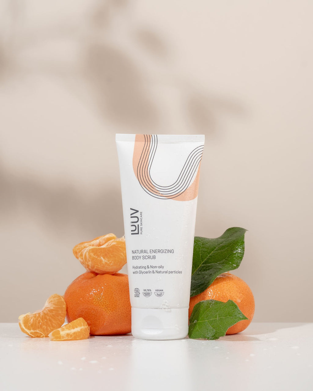 1. LUUV Natural Energizing Body Scrub tube with orange and mandarin slices on a light background