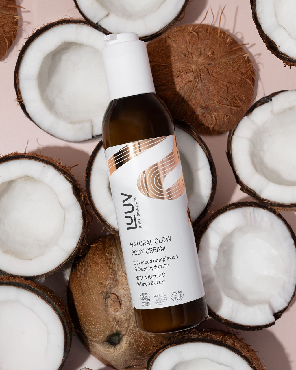 2. LUUV Natural Glow Body Cream surrounded by halved coconuts, emphasizing the product's natural and hydrating properties