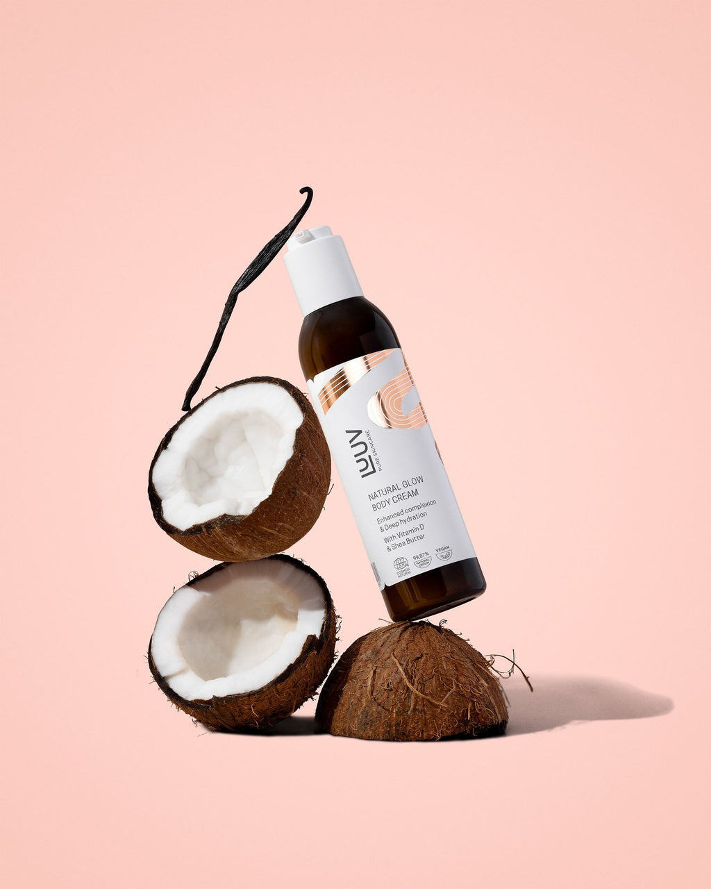 1. LUUV Natural Glow Body Cream bottle with coconuts on a pink background, highlighting the product's coconut scent and natural ingredients