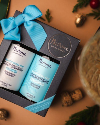 4. Nurme hair care gift set with scalp soothing shampoo and strengthening conditioner in a festive setting with a blue ribbon and holiday decorations