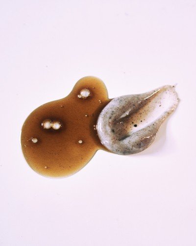 3. Close-up of Nurme peat shampoo and conditioner textures, showing brown and creamy substances on a light background