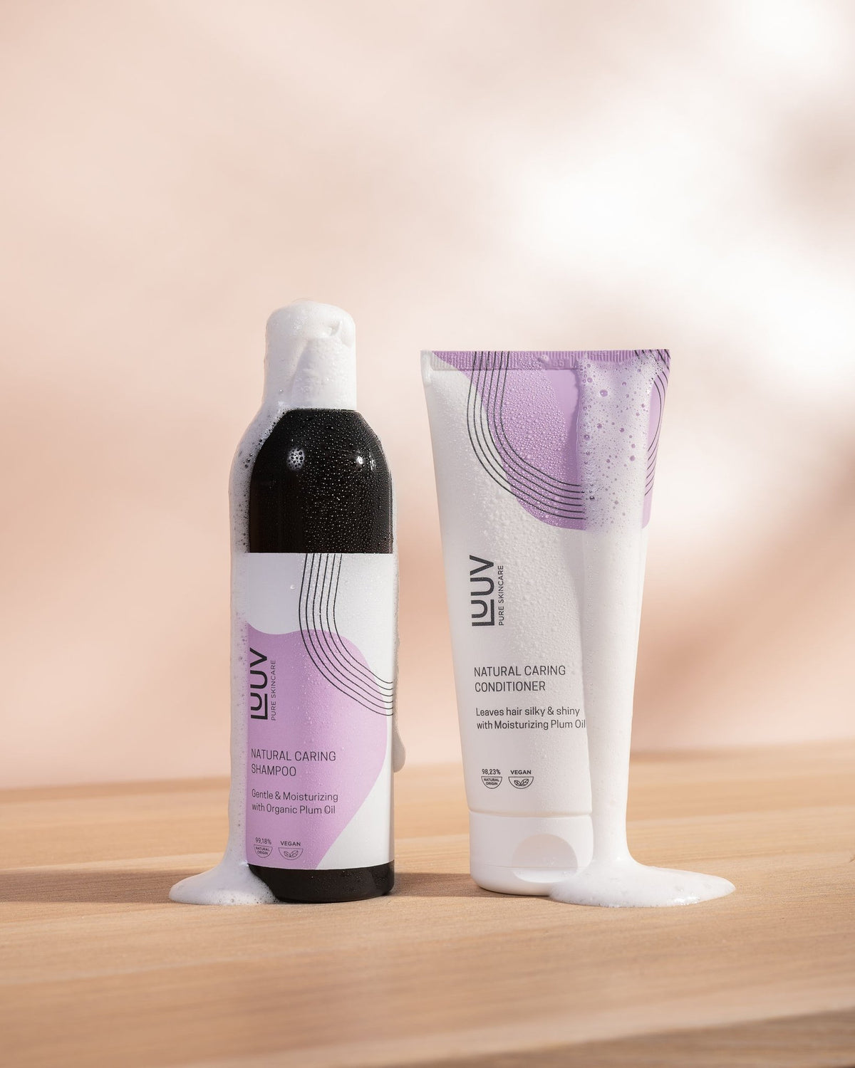 1. LUUV Natural Nourishing Shampoo and Conditioner Set with organic plum oil, shown with foamy texture on wooden surface