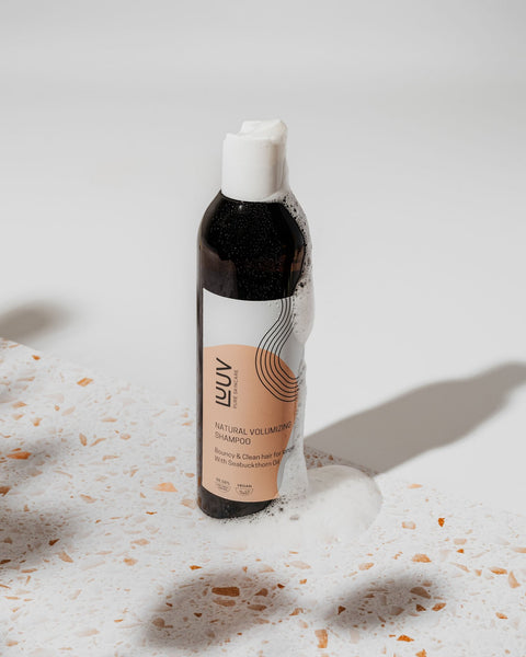 1. LUUV Natural Sea Buckthorn Shampoo bottle with suds on terrazzo surface, showcasing hydrating formula