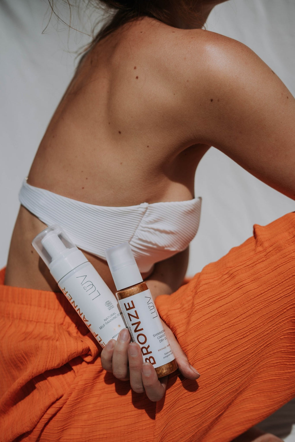 3. LUUV Natural Self Tanning Dry Oil being dispensed onto leg for natural glow