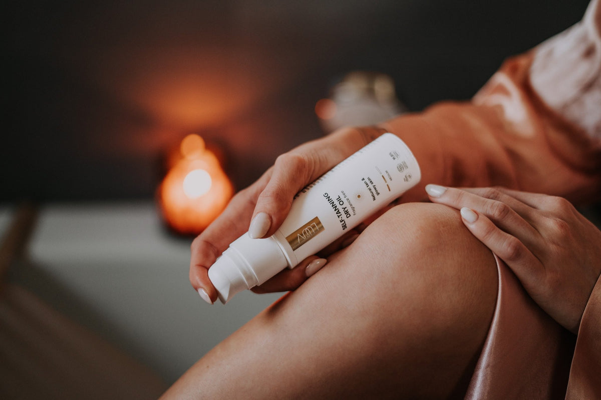 2. Woman applying LUUV Natural Self Tanning Dry Oil with mitt, highlighting smooth application on leg