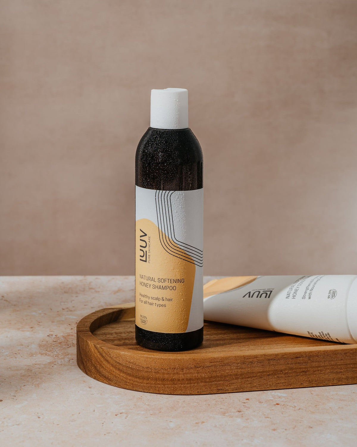 1. LUUV Natural Softening Honey Shampoo, 250 ml, displayed on a wooden tray in a lifestyle setting
