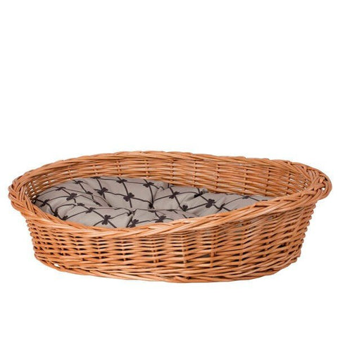 1. Natural wicker dog bed with beige cushion featuring black pattern, shown in studio setting