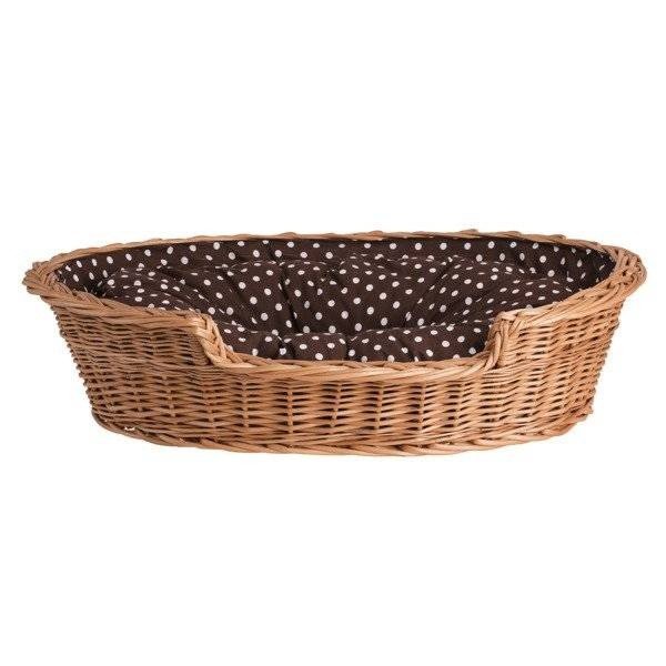 1. Natural wicker dog bed with polka dot cushion on wooden floor against brick wall