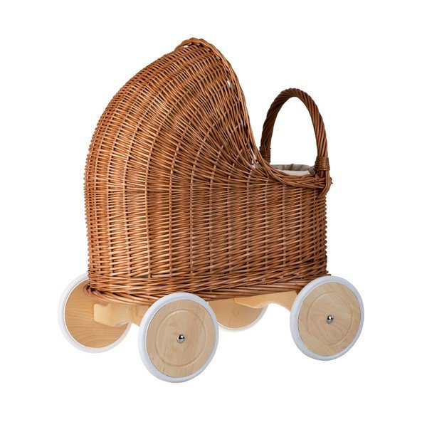 4. Side view of natural wicker doll pram with beige bedding and wooden wheels in studio