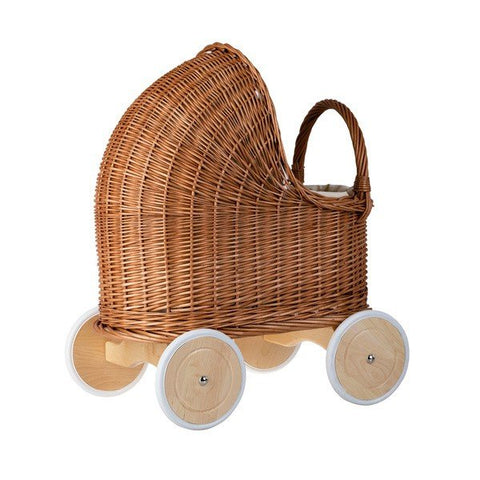 4. Side view of natural wicker doll pram with beige bedding and wooden wheels in studio