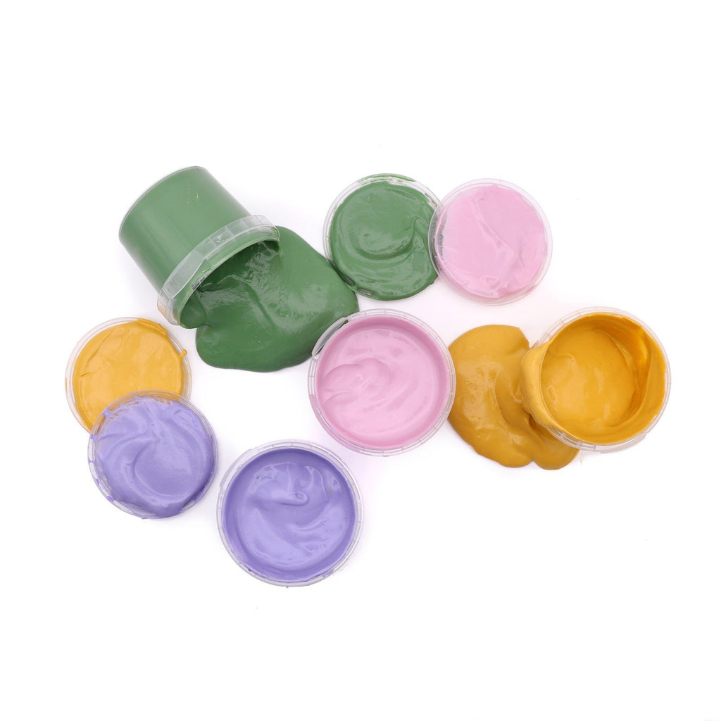4. Flat lay of Neogrün finger paints with spilled green and yellow paint, showing open jars in pink, violet, and green