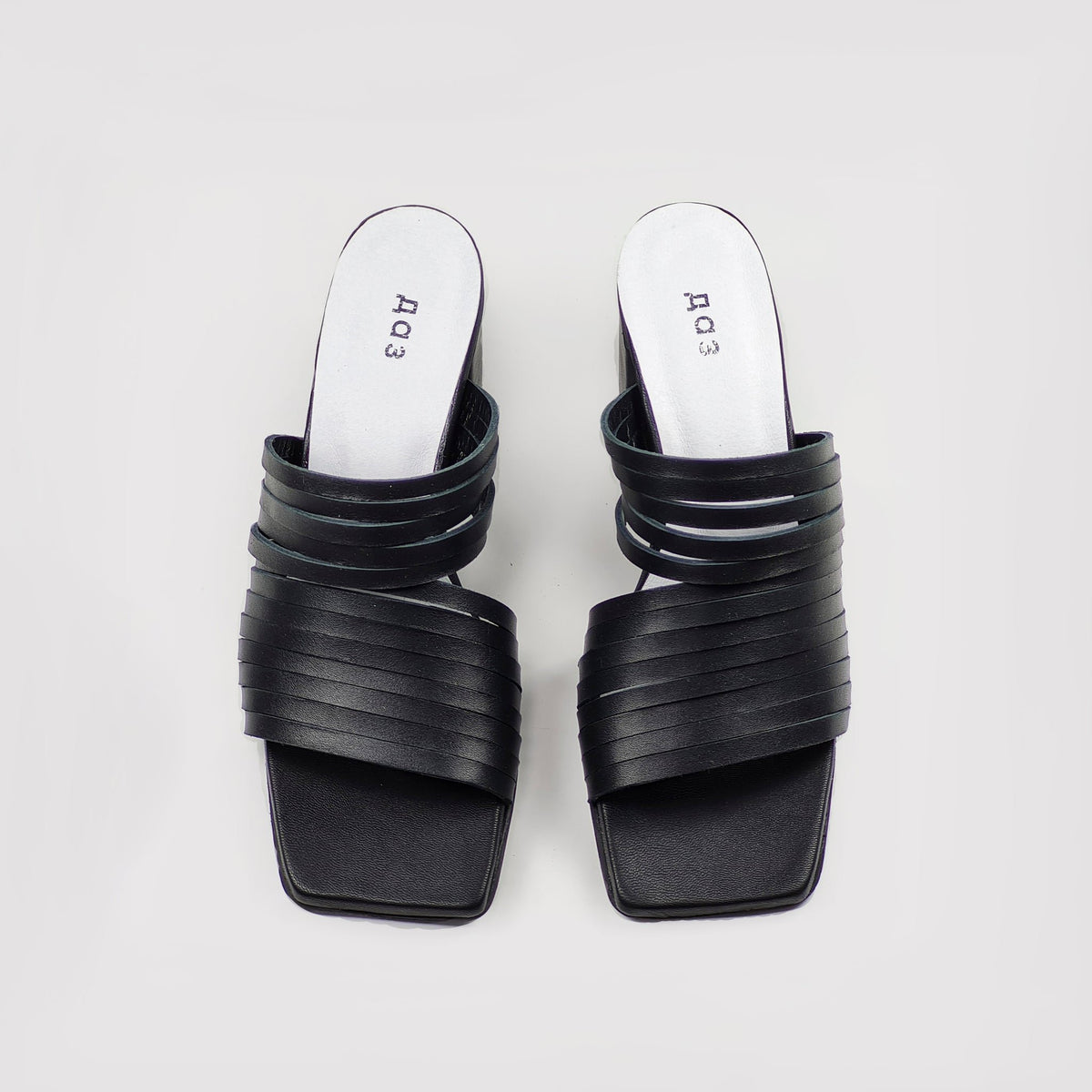 1. Women's handmade strappy matt leather sandals in black, top view showing sleek design and squared toe